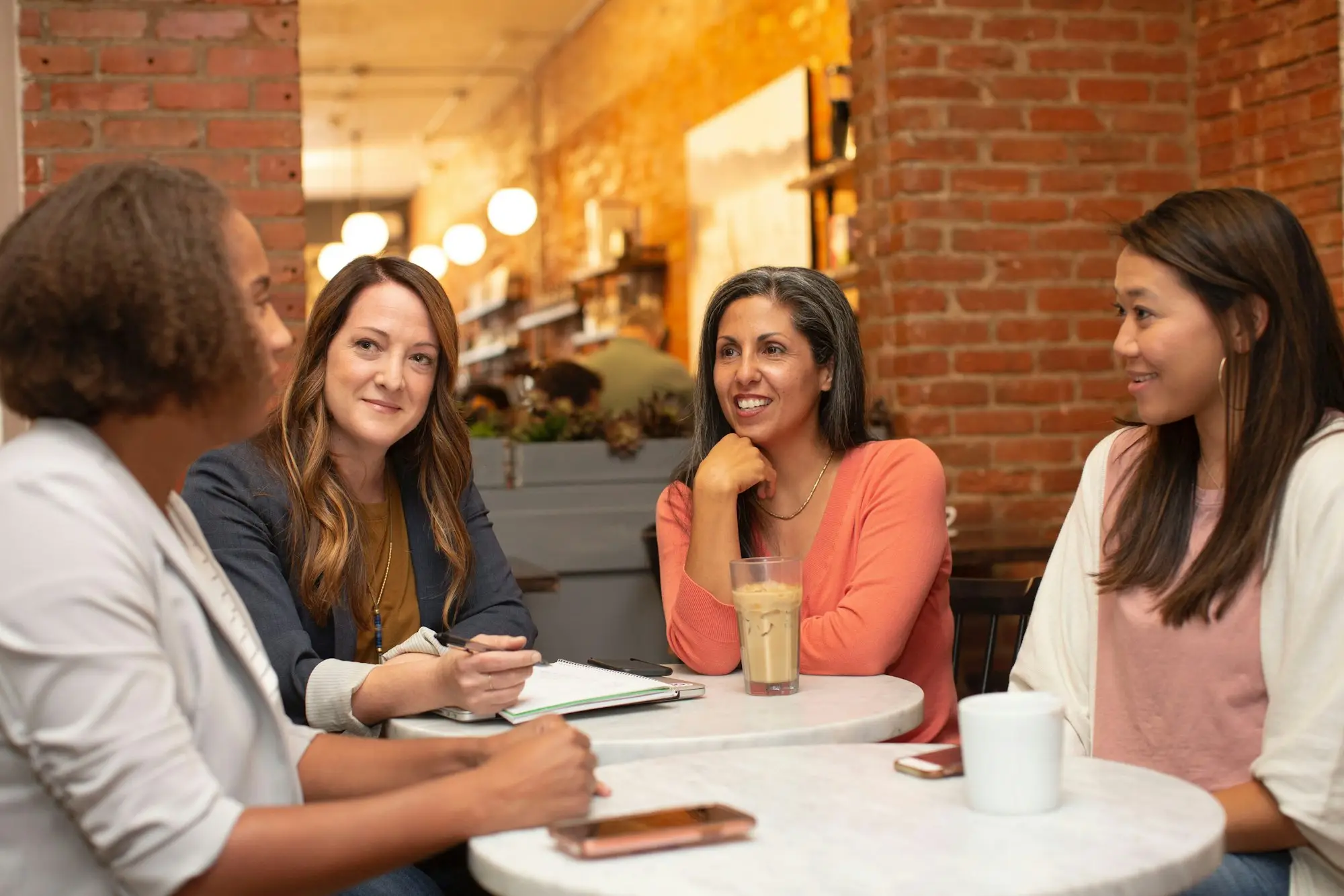 Women talking business at a café table