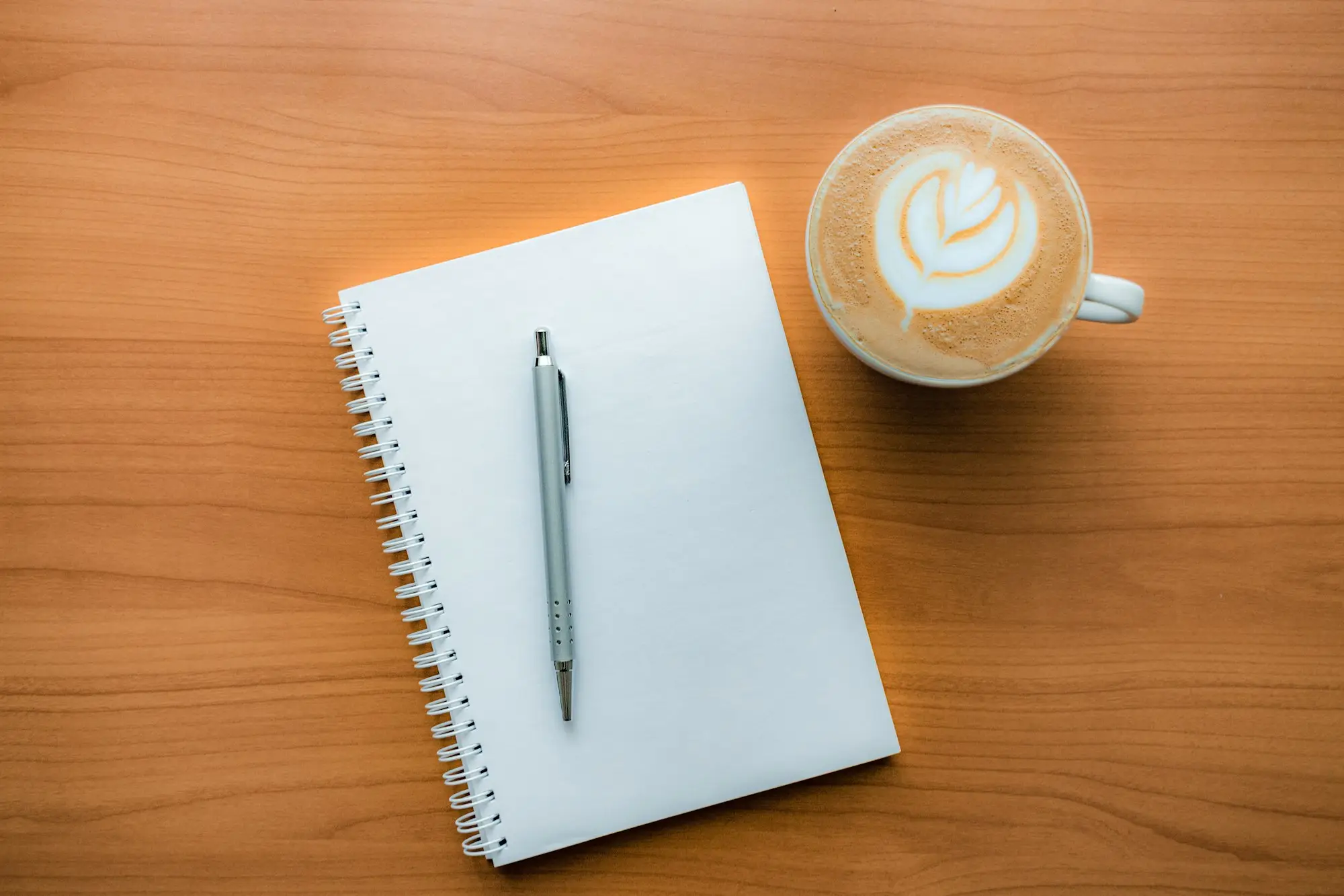 Notebook, pen and a cup of coffee